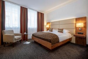 um quarto de hotel com uma cama e uma cadeira em Hotel IMLAUER Wien em Viena