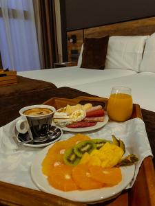bandeja de comida con fruta y bebida en la cama en Hotel BH San Francisco Alicante, en Alicante