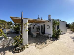 a small white house with a picnic table in the yard at Trulli di Ivana in Ostuni