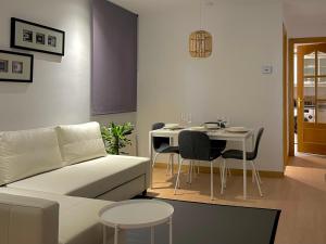 a living room with a white couch and a table at Carte du Monde by ARoom VUT-LE-967 in León
