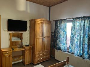 sala de estar con TV y armario de madera en Orehite Guest House, en Samokov