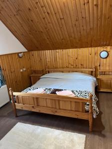 a bedroom with a bed in a wooden room at Orehite Guest House in Samokov