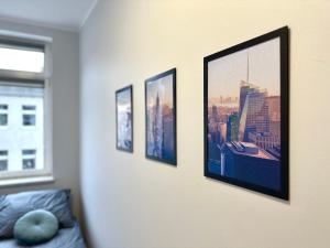 a room with four pictures hanging on a wall at MMRent New York Room in Gdańsk