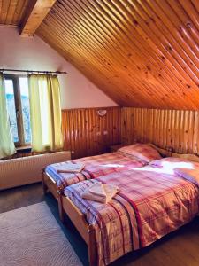a bedroom with a bed in a room with wooden walls at Orehite Guest House in Samokov