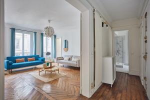 a living room with a blue couch and a table at Apartment beaubourg by Studio prestige in Paris