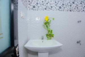 a yellow flower sitting on a sink in a bathroom at Seyoo Villa in Ahangama
