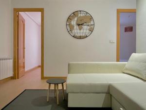 salon z kanapą i zegarem na ścianie w obiekcie Carte du Monde by ARoom VUT-LE-967 w mieście León