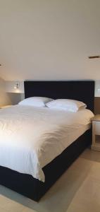 a bedroom with a large bed with white sheets at MOXIE LUXURY APARTMENTS in Belfast
