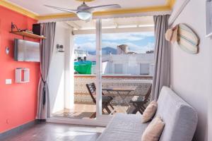 Habitación con sofá y balcón con mesa. en Apartment Calle Larga, en Fuengirola