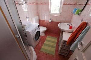 La salle de bains est pourvue d'un lave-linge et d'un lavabo. dans l'établissement Apartments Luka, à Rogoznica