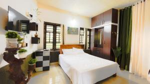 a bedroom with a white bed in a room at Dream Veedu Home Stay Banasura in Padinjarathara