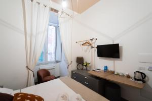 1 dormitorio con escritorio, 1 cama y TV en Palazzo il Convento en Nápoles