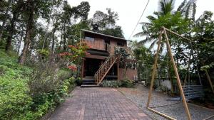 a house with a walkway in front of it at Dream Veedu Home Stay Banasura in Padinjarathara