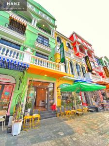un edificio colorato con sedie e ombrelloni su una strada di HANZ VeniceRiver Power MIA Grand World a Phu Quoc