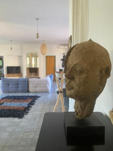 una escultura de una cabeza sobre una mesa en una sala de estar en villa marrakech avec piscine en Tameslouht