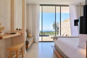 a bedroom with a bed and a view of the ocean at Hôtel Cala di Greco in Bonifacio