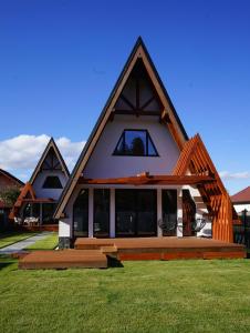 ein Haus mit einem Gamer-Dach und einer Veranda in der Unterkunft Relax Cabins in Cristian