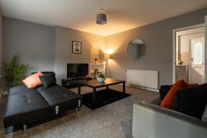 a living room with a couch and a table at The Bowhouse in Grangemouth