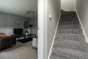 a stairway leading to a living room with a table at The Bowhouse in Grangemouth