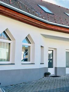 een huis met drie ramen aan de zijkant bij Studio apartman in Kőszeg
