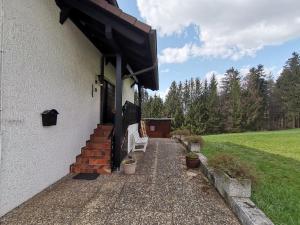 a porch of a house with a bench and stairs at Ferienwohnung am Sonnenberg in Hammelbach