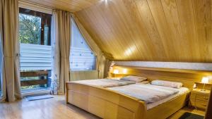 Bett in einem Zimmer mit einem großen Fenster in der Unterkunft Ferienwohnungen Seeblick in Unterkirnach