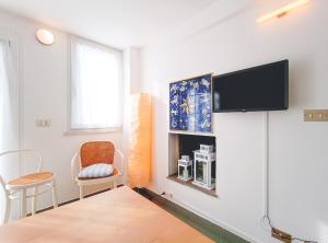 uma sala de estar com uma televisão de ecrã plano na parede em Attico a Marina Centro em Rimini