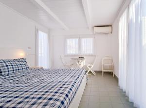 um quarto branco com uma cama azul e branca em Attico a Marina Centro em Rimini