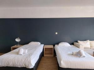 2 łóżka w pokoju z niebieską ścianą w obiekcie Room in Studio - Value Stay Residence Mechelen - Executive Studio Double w mieście Mechelen