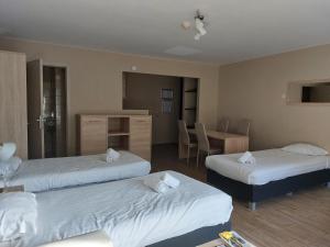 Habitación de hotel con 3 camas y mesa en Room in Studio - Value Stay Residence Mechelen - Executive Studio Double, en Malinas