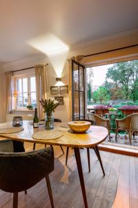 uma sala de jantar com uma mesa e uma grande janela em Vakantiewoning 'De Teut' em Zonhoven