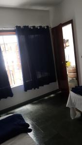 a bedroom with a bed and a window and a door at Hostel BoituVillage in Boituva