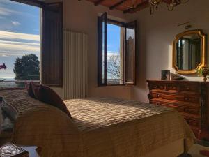 1 dormitorio con 1 cama, vestidor y ventanas en House with a view in Tuscany, en San Gusmè
