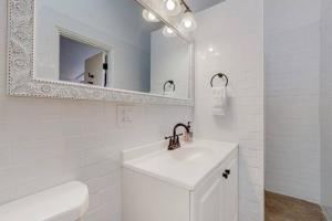 a white bathroom with a sink and a mirror at A la Veta Guest Studio in Albuquerque
