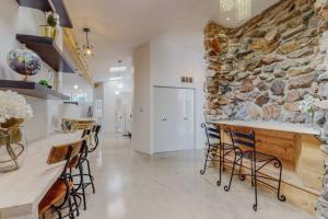 a large kitchen with a stone wall and chairs at A la Veta Guest Studio in Albuquerque