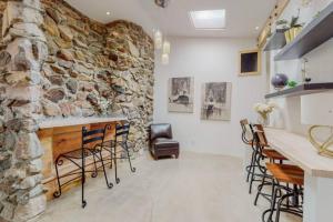 a room with chairs and a stone wall at A la Veta Guest Studio in Albuquerque