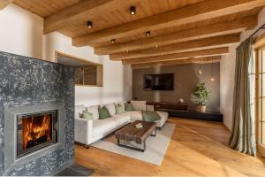a living room with a fireplace and a couch at Almwelt Austria in Schladming