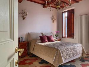 Un dormitorio con una cama con almohadas moradas y una ventana en House with a view in Tuscany, en San Gusmè
