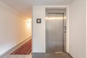 a elevator in a hallway with a clock on a wall at Apartments Soval in Santa Cristina Gherdëina