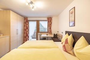 a hotel room with two beds and a table at Apartments Soval in Santa Cristina Gherdëina