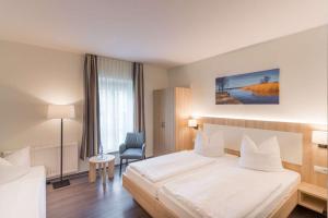 a hotel room with a bed and a chair at BSW Hotel Ahlbeck in Ahlbeck +36 photos
