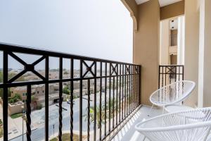 a balcony with white chairs and a view at Nasma Luxury Stays - Fabulous Apartment With Balcony Near MJL's Souk in Dubai