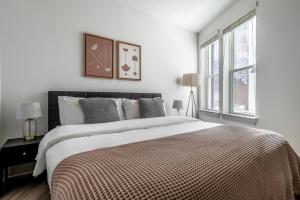 a white bedroom with a large bed and a window at Downtown 1br w deck gym nr Congress Ave ATX-208 in Austin