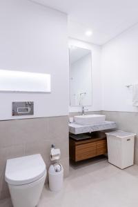 a bathroom with a white toilet and a sink at Nasma Luxury Stays - Fabulous Apartment With Balcony Near MJL's Souk in Dubai