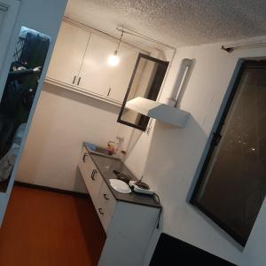 eine kleine Küche mit einem Waschbecken und einem Fenster in der Unterkunft Maya Suite in Cuenca
