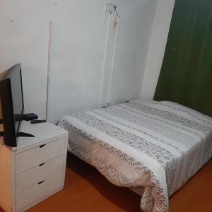 ein Schlafzimmer mit einem Bett und einem TV auf einer Kommode in der Unterkunft Maya Suite in Cuenca