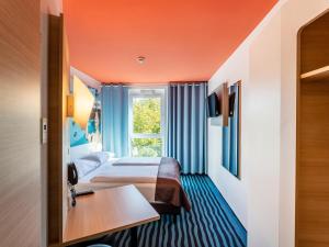 een hotelkamer met 2 bedden en een raam bij B&B Hotel Konstanz in Konstanz