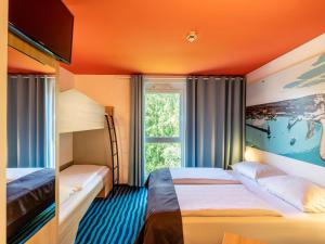 a hotel room with two beds and a window at B&B Hotel Konstanz in Konstanz