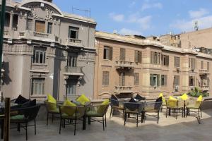 un groupe de chaises et de tables devant les bâtiments dans l'établissement El Shams Plaza Hotel, au Caire