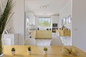 una gran cocina blanca con mesa y sillas en The Lemon Tree by the Sea, en La Cala de Mijas